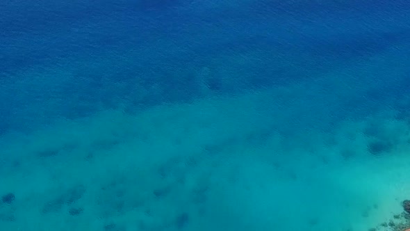 Aerial drone panorama of shore beach break by clear sea with sand background alt