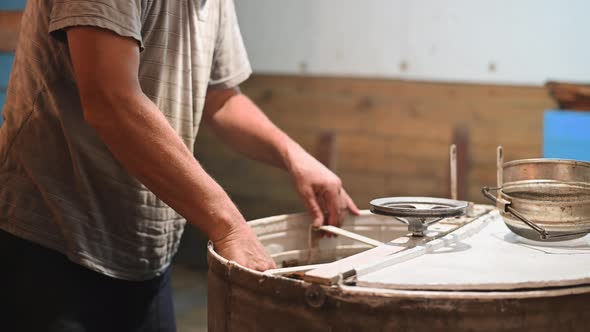 Beekeeper Is Filling Up a Honey Extractor with a Honeycomb and Spinning Uncapped Frames in the alt