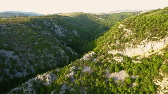Aerial view of karst landscape, with valleys and cliffs, at sunset