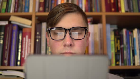 A Young Man Is Reading a Book in a Tablet. A Man with Glasses Carefully Looks at the Tablet. In the alt