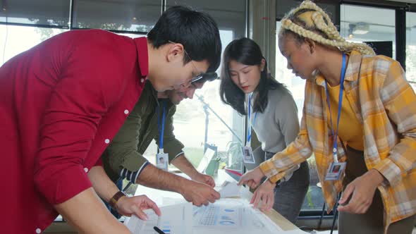 brainstorming about mobile app interface workflow design on table with coworker alt