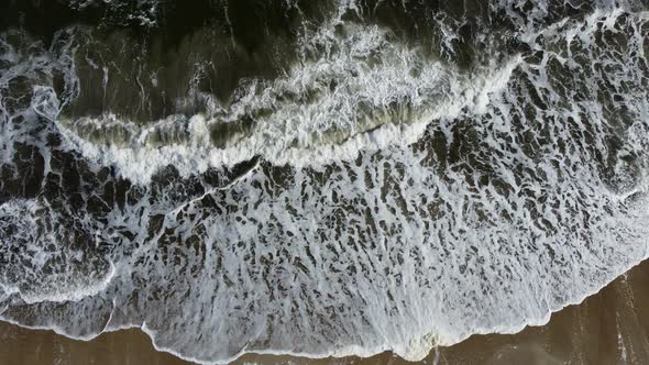 Aerial Drone View Flight Over Sea Waves That Roll Onto Sandy Shore alt