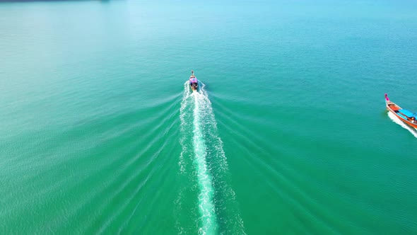 An aerial view of the boat sailing in the beautiful turquoise waters alt