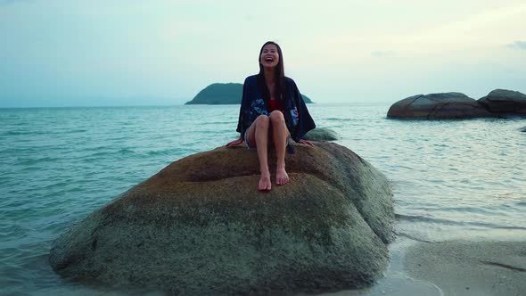 Cute Smiling Asian Girl Laughing on a Rock at Sunset in Slow Motion Thailand
