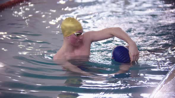Swimming Instructor Teaching a Kid How to Swim Underwater in the Pool alt