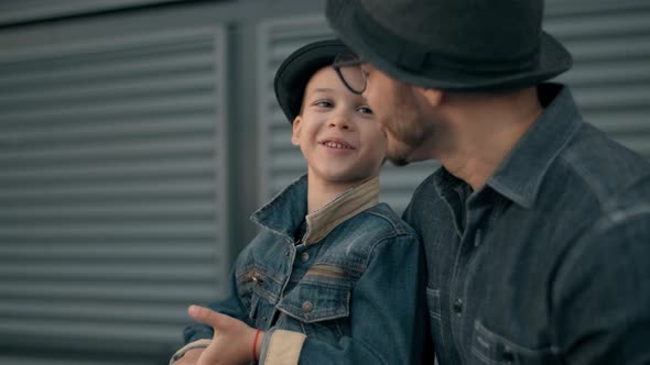 Father and Little Son Are Talking and Smiling While Spending Time Together Outdoor alt