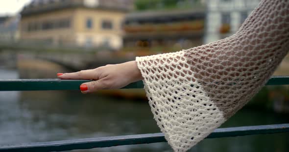 Young Woman Hand with Manicure Lies on Bridge Handrail alt
