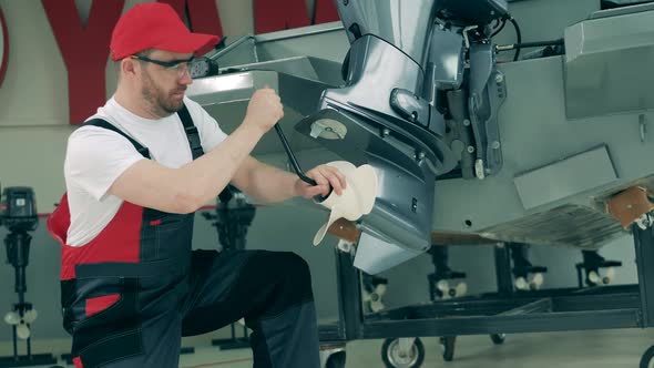 Workshop Specialist Is Doing Maintenance of a Motorboat alt