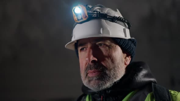 Headshot Portrait Confident Mature Man Looking Around Standing in Frozen Ice Cave with Stalactites alt
