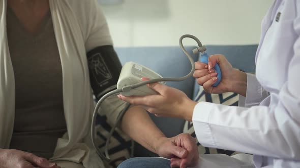 Assistant of Practitioner Checking Pressure of Mature Old Woman alt
