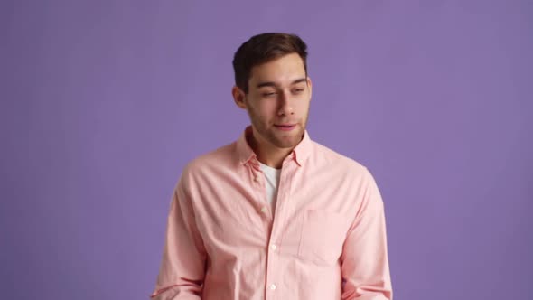 Studio Portrait of Cheerful Handsome Young Man Applauding and Pointing Fingers Making Double Thumbs alt