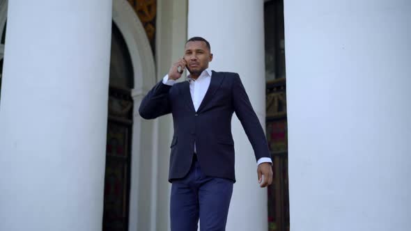 Handsome African American Businessman Walking Down Stairs Talking on the Phone alt