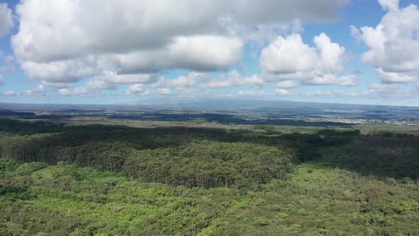 Wide aerial panning shot of both Mauna Loa and Mauna Kea volcanoes with their summits hidden by clou alt