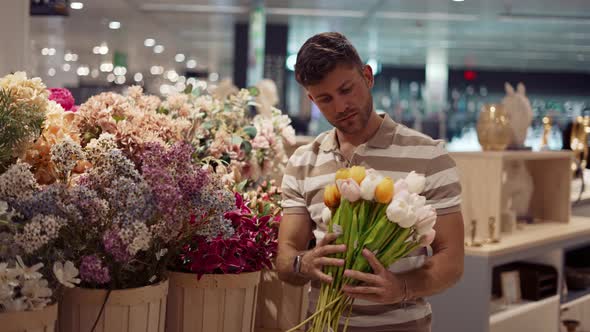 Man Choosing Flowers in Floral Shop alt