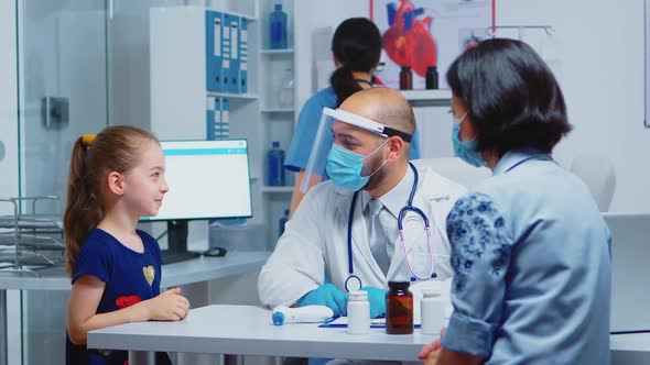 Cheerful Pediatrician Smiling at Little Girl alt