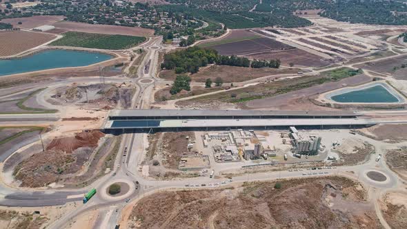 Aerial footage of large highway construction project with tunnels and bridges alt