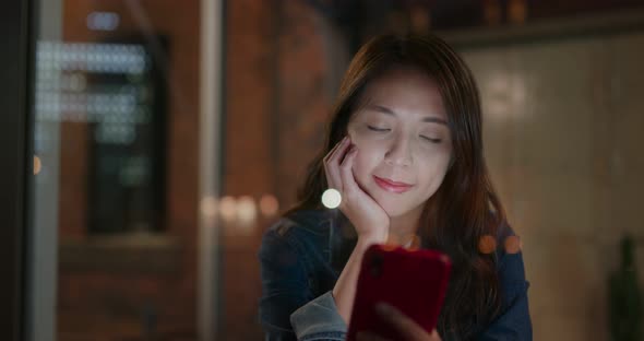 Woman use of mobile phone in coffee shop at night alt