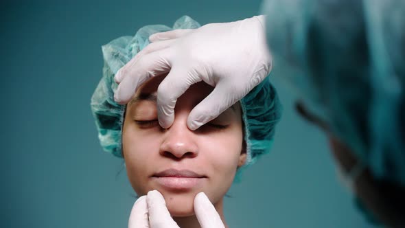 Surgeon Examines Girl's Face Before Rhinoplasty Wearing Protective Gloves alt
