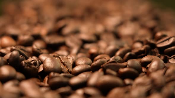 Roasted coffee beans falling down in golden light alt
