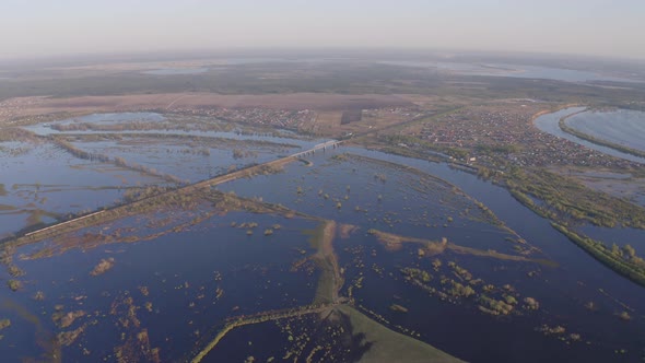 Aerial Drone Footage of a Freight Train Passes a Bridge in High Water