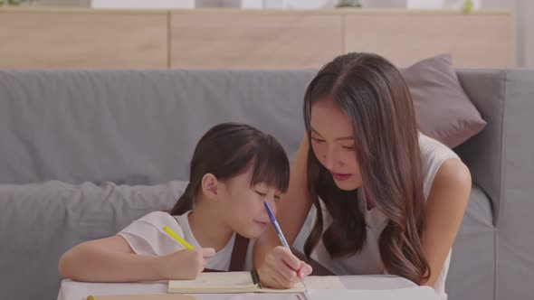 Happy asian young mother smile with daughter in living room at home alt