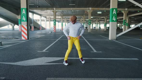 Cheerful and Happy Young Man with Beard Actively Is Dancing While Walking Down the Street on Urban alt