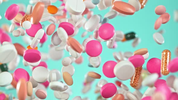 Super Slow Motion Shot of Flying Colorful Pills on Light Blue Background at 1000Fps alt