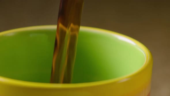 PAN LEFT, Black coffee is poured into a colourful mug, left steaming. 60fps alt