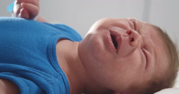 Close Up of Crying Newborn Baby on Changing Table alt