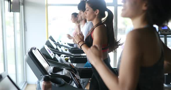 Group of Young People Running on Treadmills in Sport Gym