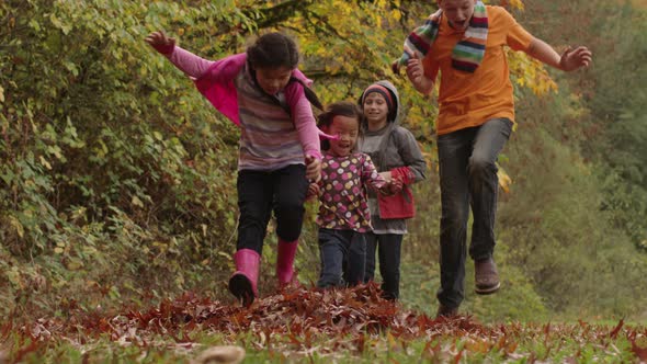 Group of kids in Fall throwing leaves