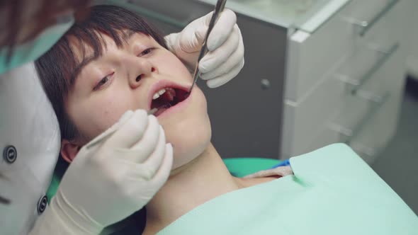 Female dentist working in her dentist office. Dental clinic. Reception, examination of the patient. alt