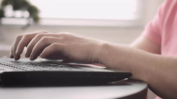 Hands of a Man in a Pink Tshirt Who Works on a Laptop Camera Tracking alt