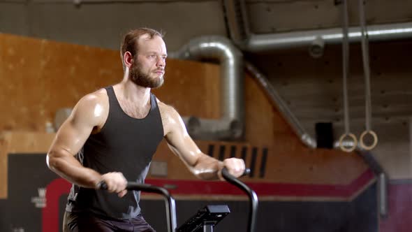 Sportsman Spinning an Air Bike in Gym, Cycling Cardio Workout Endurance Training