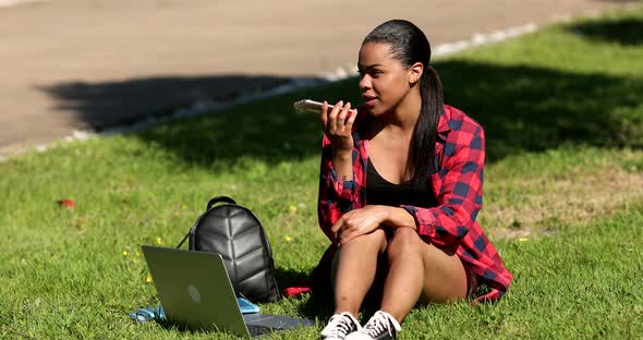 Young african american woman dictating voice message. alt