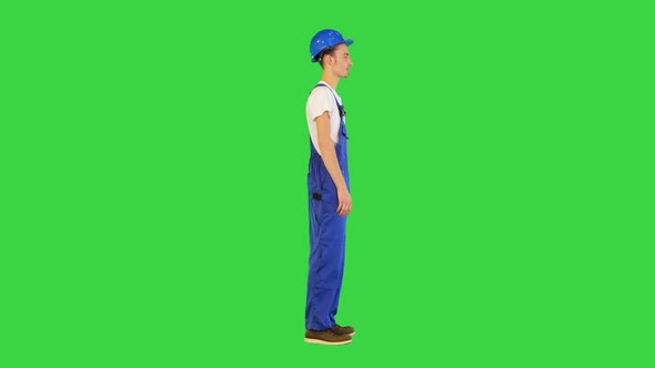 Young Construction Worker Smiling with Hands on His Hips on a Green Screen Chroma Key alt