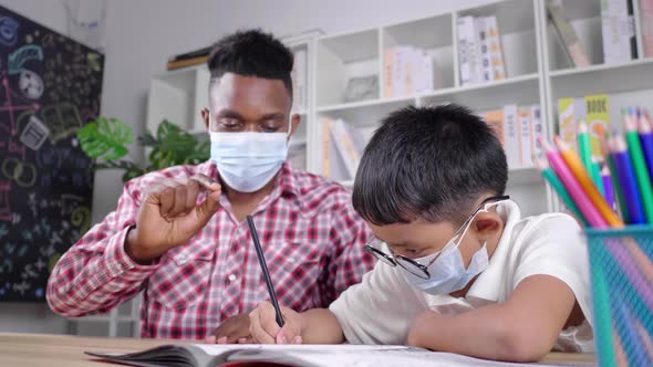 African teacher and student sitting in a room and wearing mask in private class to protect COVID19 alt