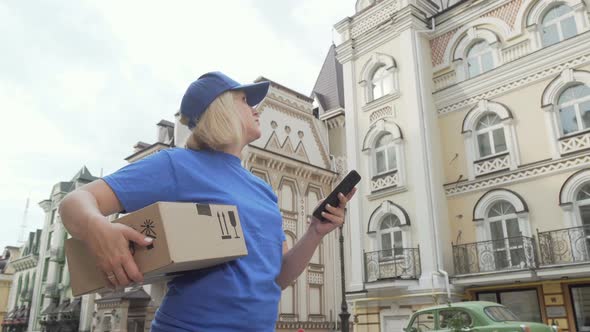 Delivery Woman with Parcel Box Using Smart Phone Online Map