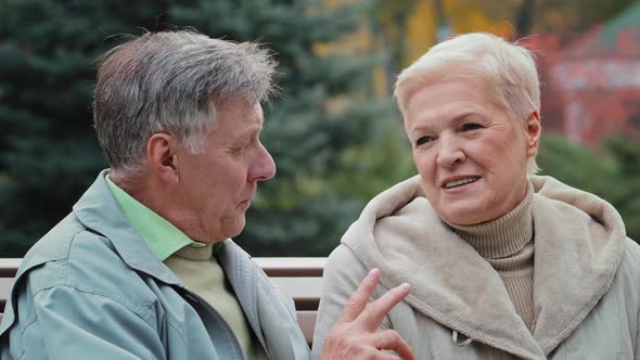 Elderly Caucasian Married Couple Lovely Grandparents Family Sitting on Bench in Autumn Park Enjoying alt