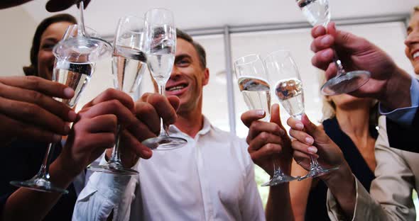 Group of smiling friends toasting champagne glass alt