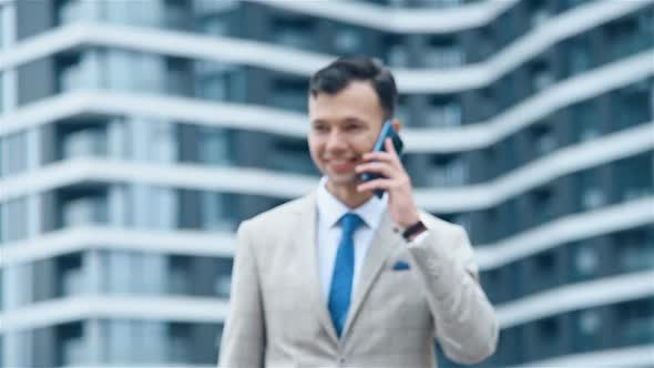 Businessman Walking And Talking On Mobile Phone.