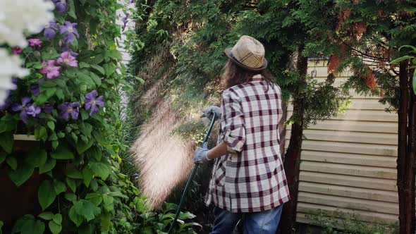 Woman Watering Plants in Garden alt