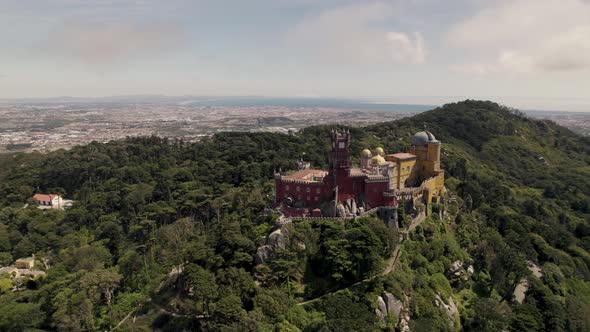 Pena Palace, hilltop castle surrounded by lush forest in Sintra, Lisbon, Portugal. Orbiting shot. alt