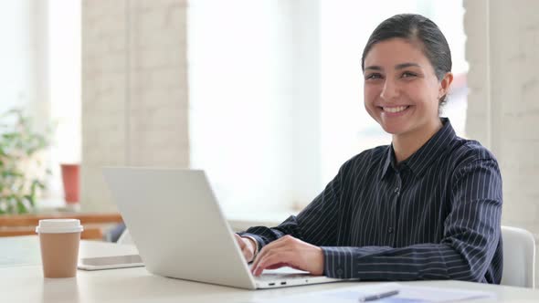 Cheerful Young Indian Woman with Laptop Smiling at Camera  alt