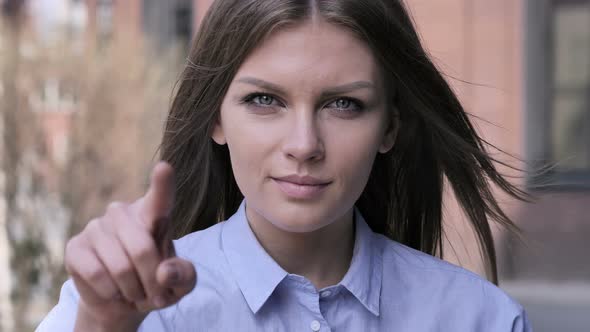 Young Woman Pointing toward Camera, Portrait alt