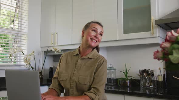 Caucasian senior man giving a flower bouquet and hugging his wife at home alt