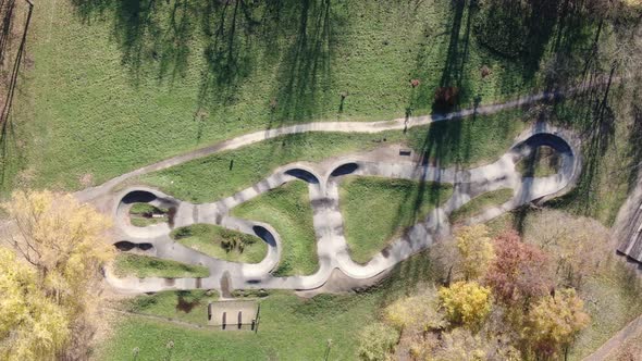 Top-down aerial view of a pumptrack in a park alt