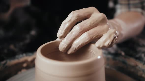 Man Potter Working on Potters Wheel Making Ceramic Pot From Clay in Pottery Workshop alt
