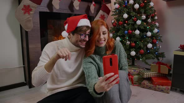 A man and a woman making selfie at Home in a Christmas atmosphere. alt