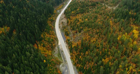 4K Aerial footage of mountain road in beautiful forest at sunset in autumn